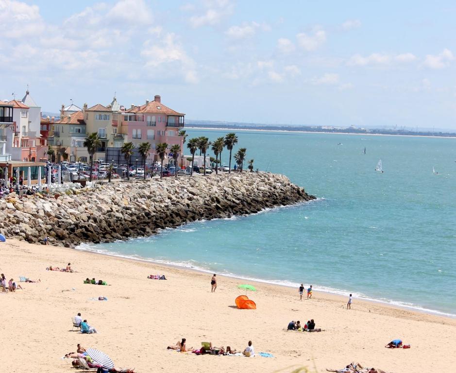 eine Gruppe von Menschen an einem Strand in der Nähe des Ozeans in der Unterkunft Apartamentos Puerto Sherry in El Puerto de Santa María