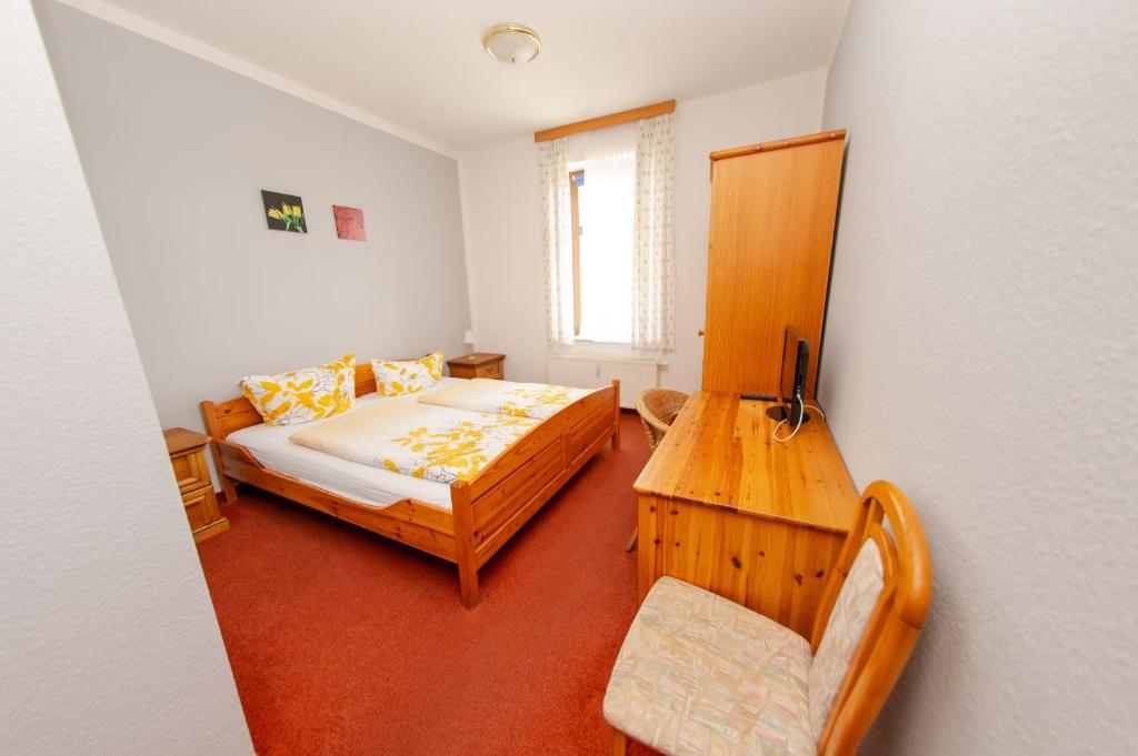 a small bedroom with a bed and a table at Aparthaus Schmiedeschenke in Dresden