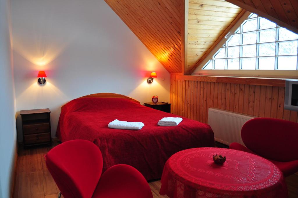 アーダジにあるGuesthouse Leiputrijaのベッドルーム(赤いベッド1台、赤い椅子付)