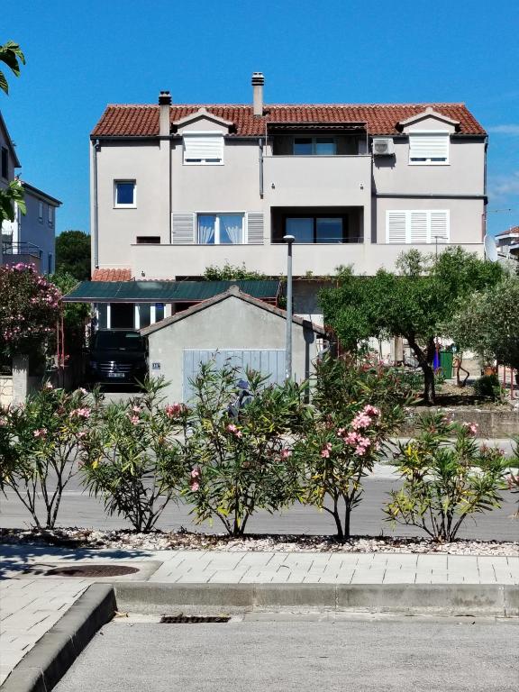 a large white house with trees in front of it at Apartment Hramina in Murter