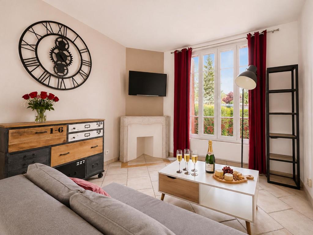 a living room with a couch and a table at T3 lumineux, central, parking & confort moderne in Saint-Cyr-lʼÉcole