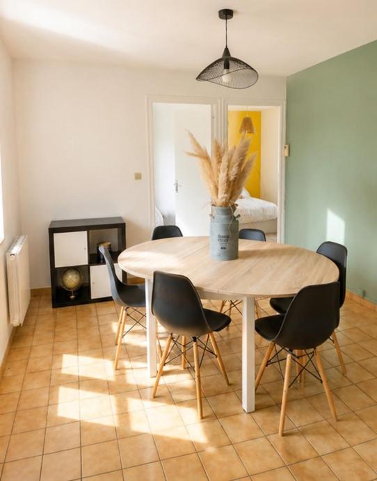a table and chairs in a living room with a table at L'échappée Verte in Saint-Jean-la-Bussière