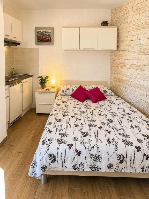 a bedroom with a large bed with red pillows at Apartment Vrančić in Šibenik
