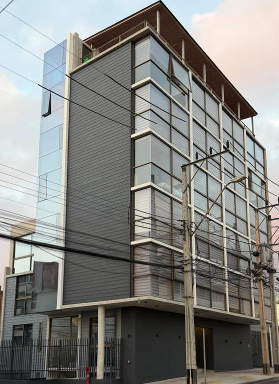 a tall building with glass windows at Hoteles JMC in Antofagasta