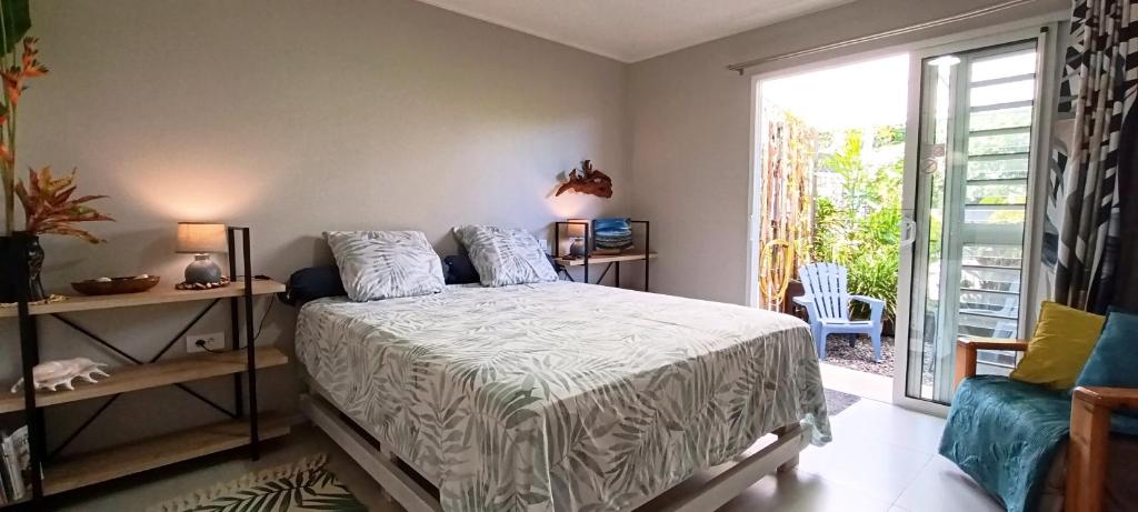 a bedroom with a bed and a large window at Teonetere Iti in Teahupoo