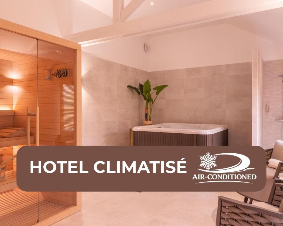 a hotel clinic sign in a room with a hot tub at Hôtel Les Nations The Originals Boutique VICHY in Vichy