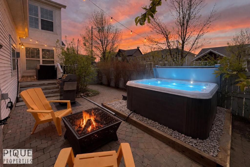 a backyard with a hot tub and a fire pit at The Obsolete Suite - HotTub - King Bed - AC - Pet Friendly in Edmonton
