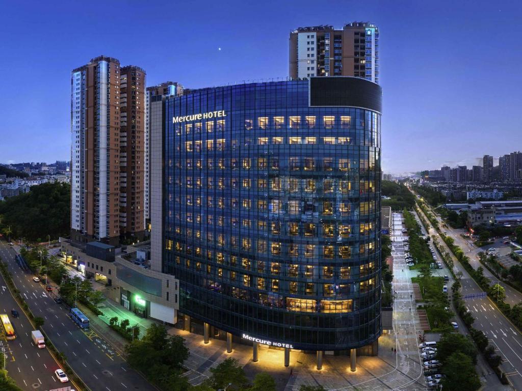 a tall building with lights on in a city at Mercure Shenzhen Longgang in Shenzhen
