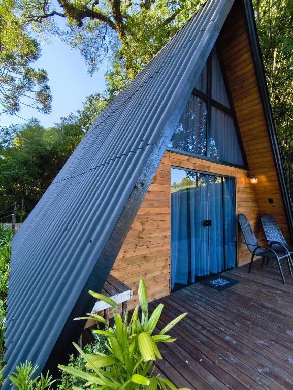 ein kleines Haus mit einem Mansarddach in der Unterkunft Chalé Riacho - Cabana em Contenda - Chalé romântico com hidromassagem in Contenda