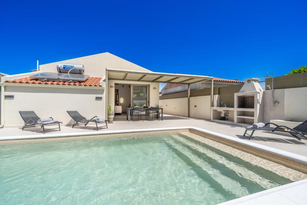 a villa with a swimming pool and a house at La Villa Du Soleil in Sami