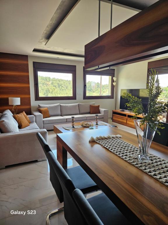 a living room with a table and a couch at Moumis Luxury Apartment in Limenaria