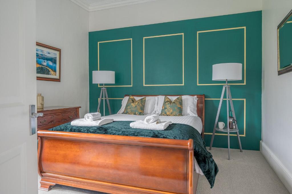 a bedroom with a bed with a green wall at Cameron Fell Apartment Keswick at The Lairbeck in Keswick