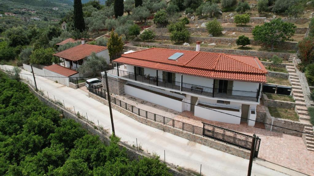 a house with a red roof and a road at Olive Hill in Ancient Epidauros