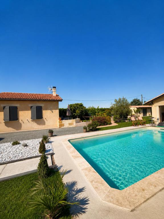 a swimming pool in front of a house at Au lit de Vin in Saint-Sulpice-de-Faleyrens