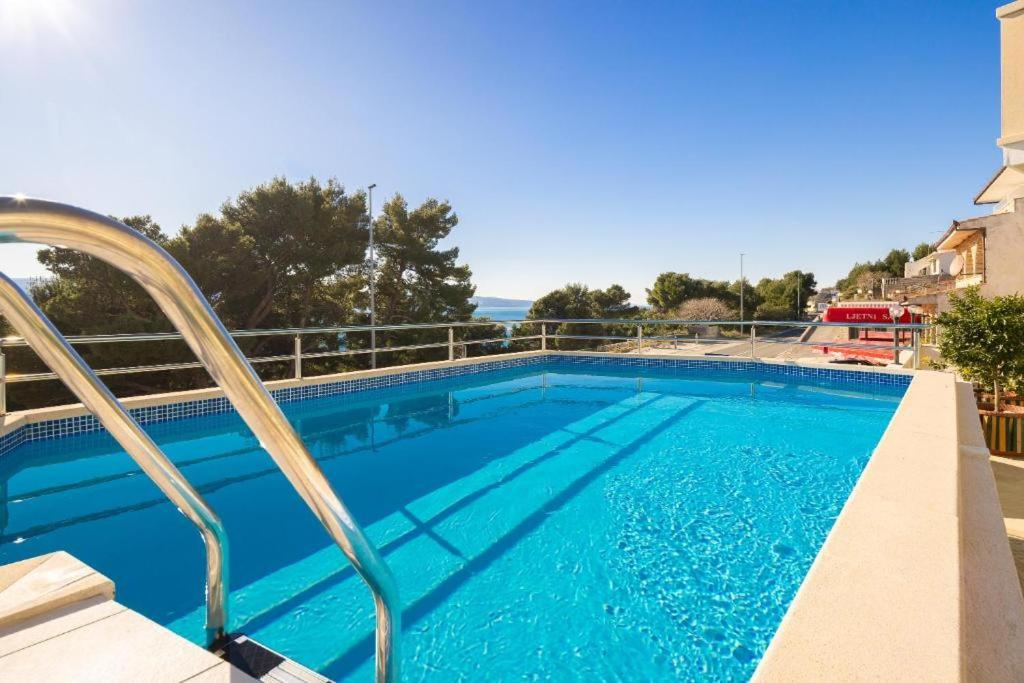 a large swimming pool with blue water at Apartmani Darijo in Čelina