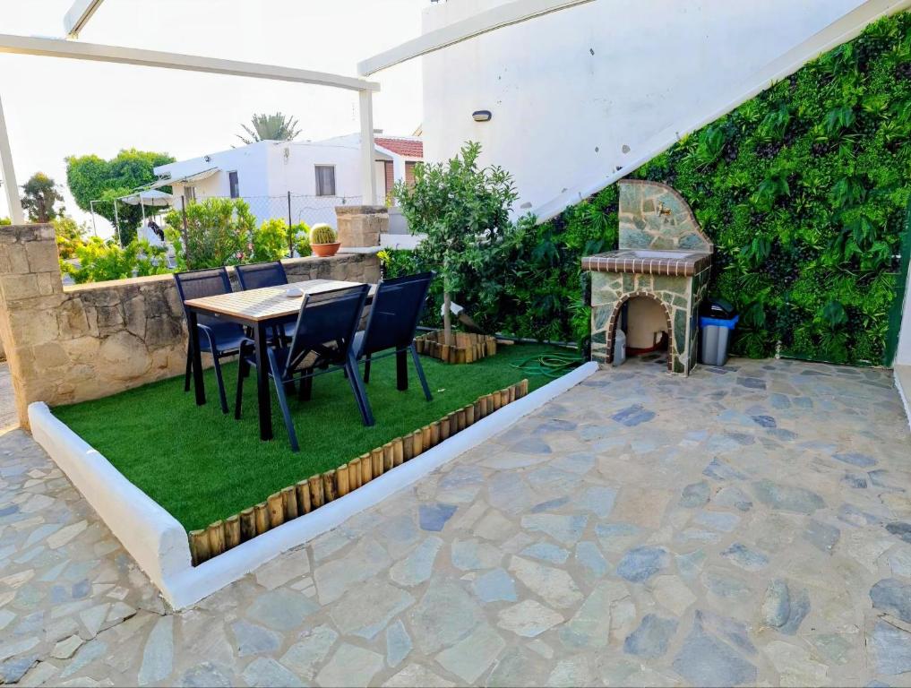 a patio with a table and chairs and a fireplace at Pefkos Sea Shell in Pefki