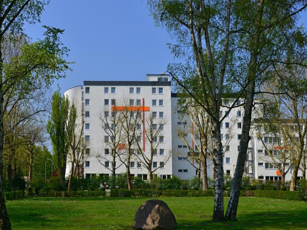 ein weißes Gebäude mit Bäumen davor in der Unterkunft enjoy hostel Berlin City West in Berlin