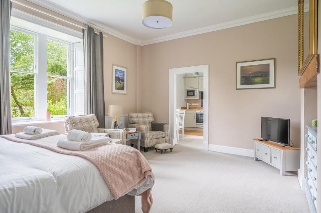 a bedroom with a bed and a living room at Bethby Beck Apartment Keswick at The Lairbeck in Keswick