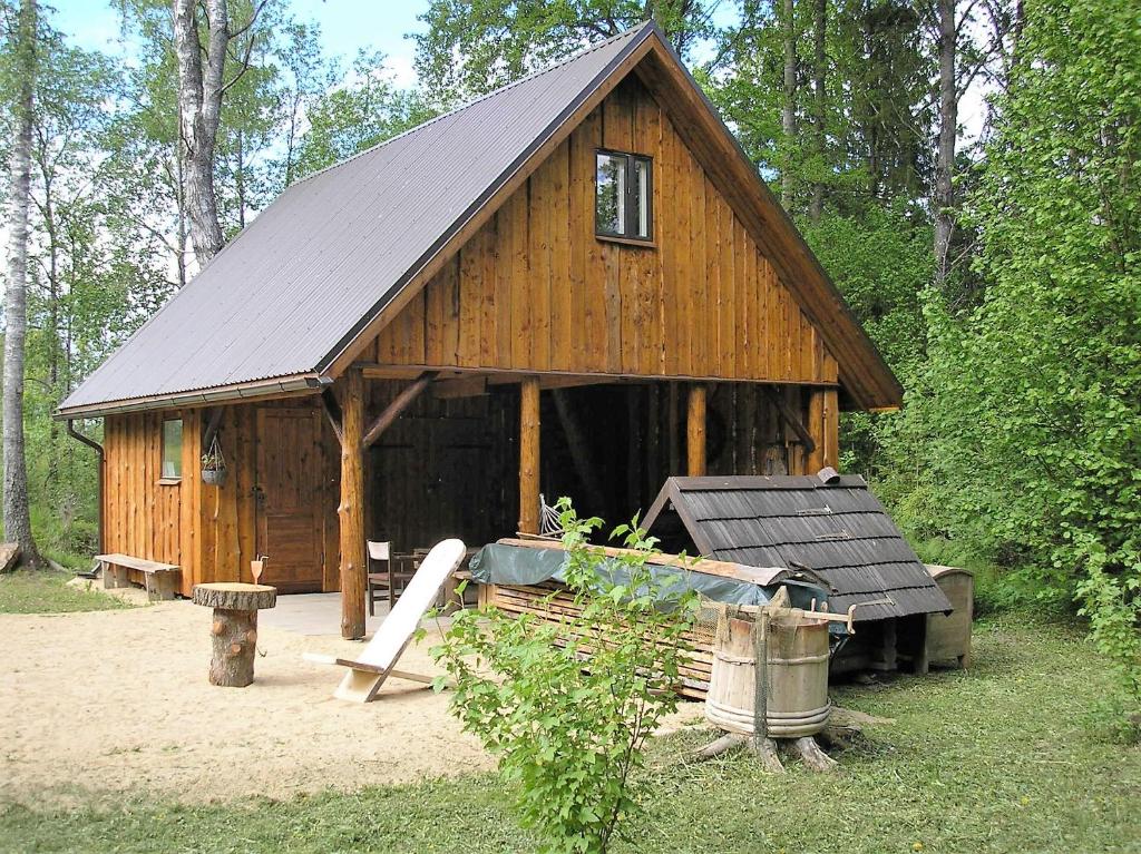 eine große Holzhütte mit schwarzem Dach in der Unterkunft Lonni Nature Eco-Accommodation in Hagudi