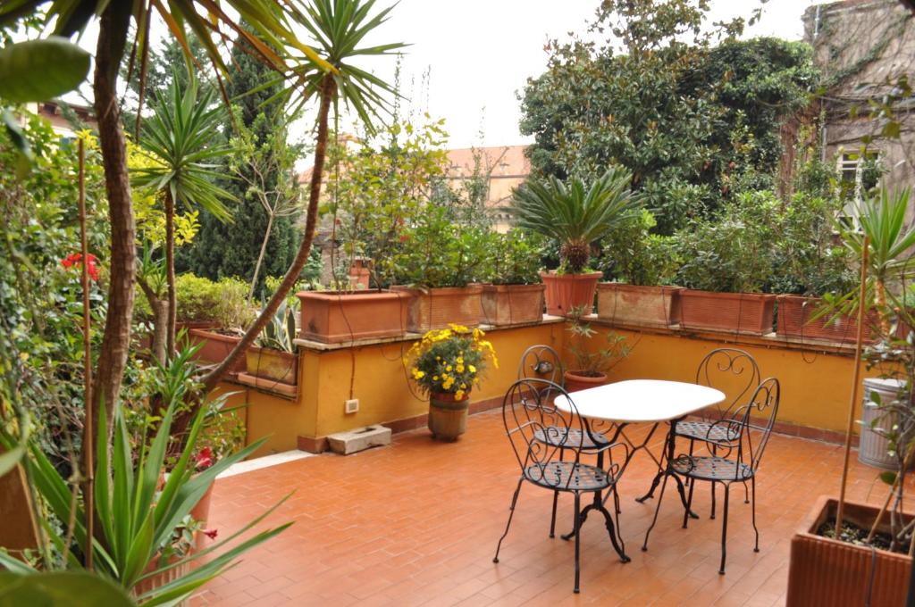un patio con tavolo, sedie e piante di Onofrio Flat a Roma