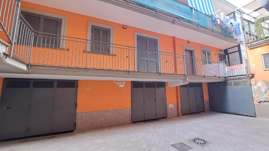 an orange building with doors and a balcony at Casa Cirillo in Marigliano