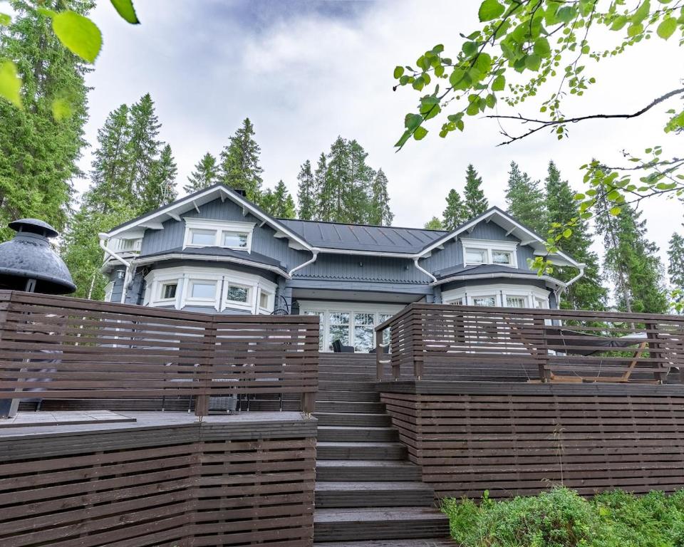 a house with a wooden fence in front of it at Mäntypirtti Log Villa in Rovaniemi