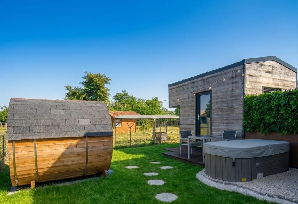 a backyard with a tiny house and a table at Maisonnette des trois frontières in Richwiller