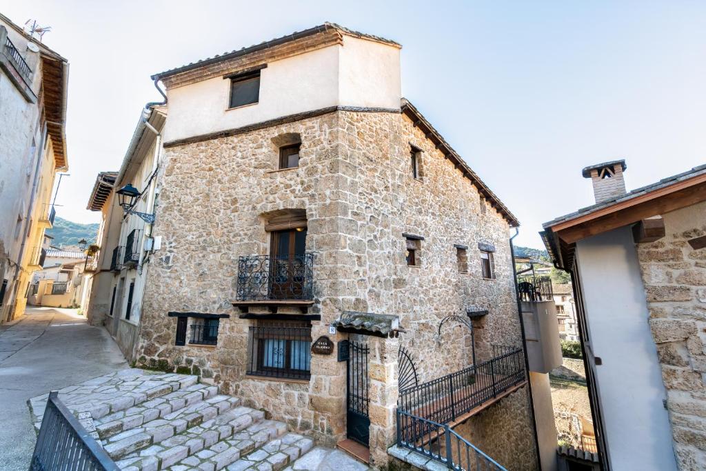 an old stone building with a balcony on a street at CASA LA FELICIDAD in Beceite