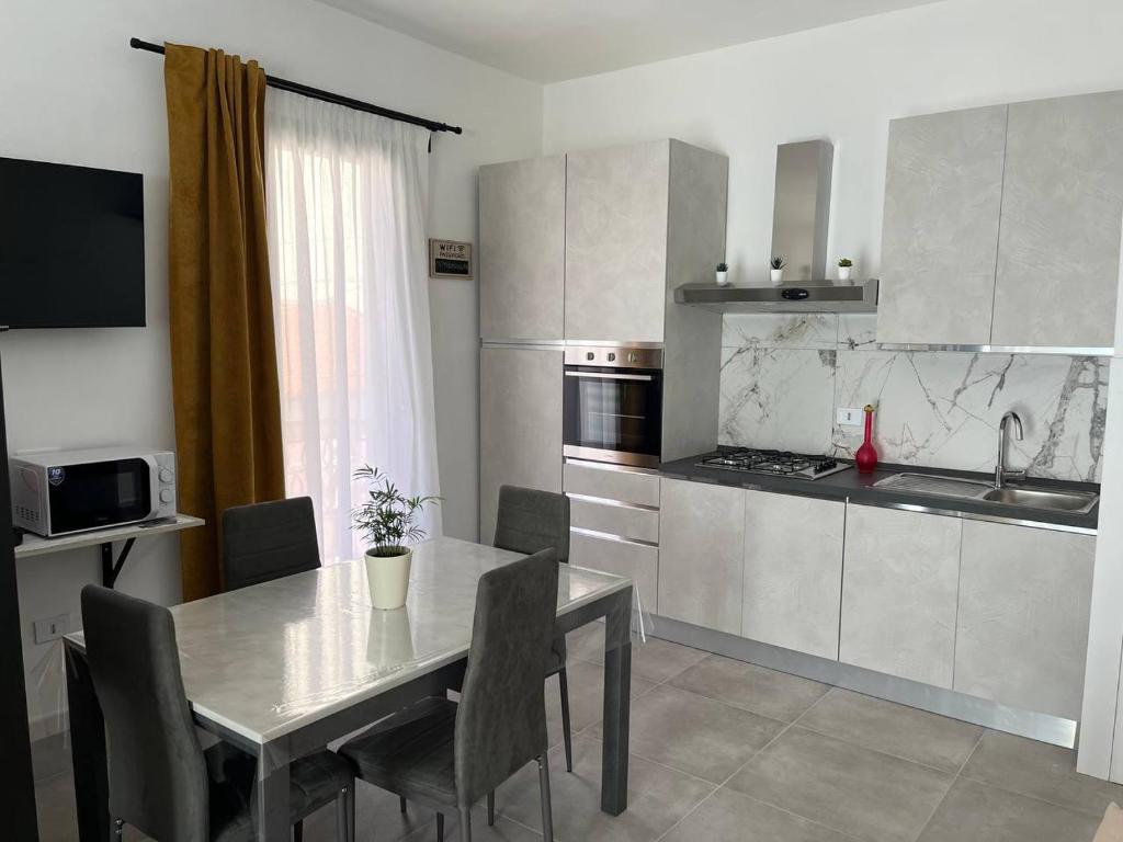 a kitchen with a table and chairs and a table and a kitchen at Apartment, Sulina's House in Campofelice di Roccella