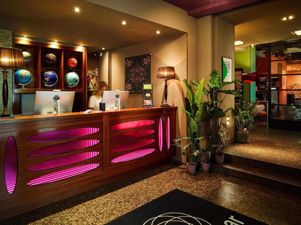 a restaurant with pink lights on a counter at 25hours Hotel The Goldman in Frankfurt