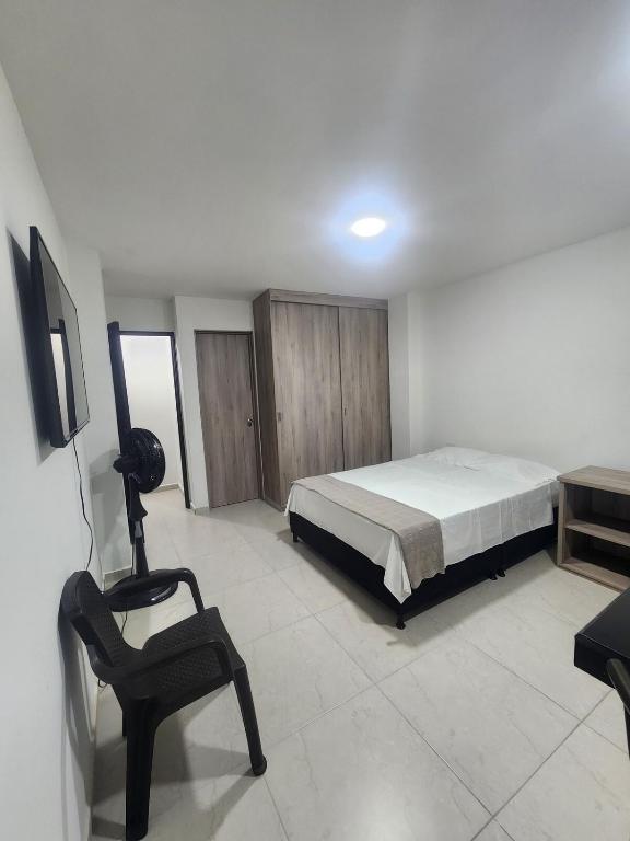 a bedroom with a bed and a chair in it at Apartaestudio 102 moderno, cómodo y tranquilo in Tuluá