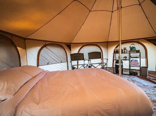 a large tent with a bed in a room at Bisti Badlands Tent in Farmington