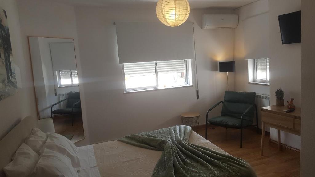 a bedroom with a bed and a desk and a chair at Moradia Vinhais in Vinhais