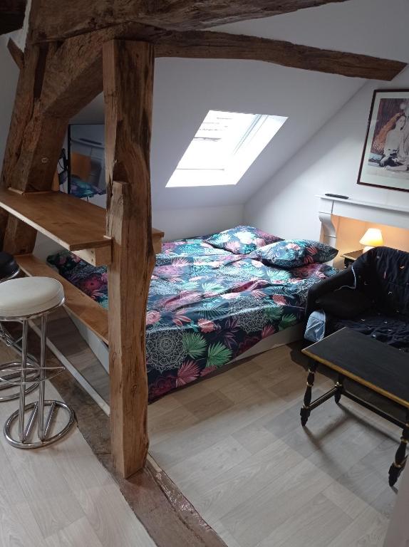 a dorm room with a bed and a desk and a chair at Studio de charme in Lormes