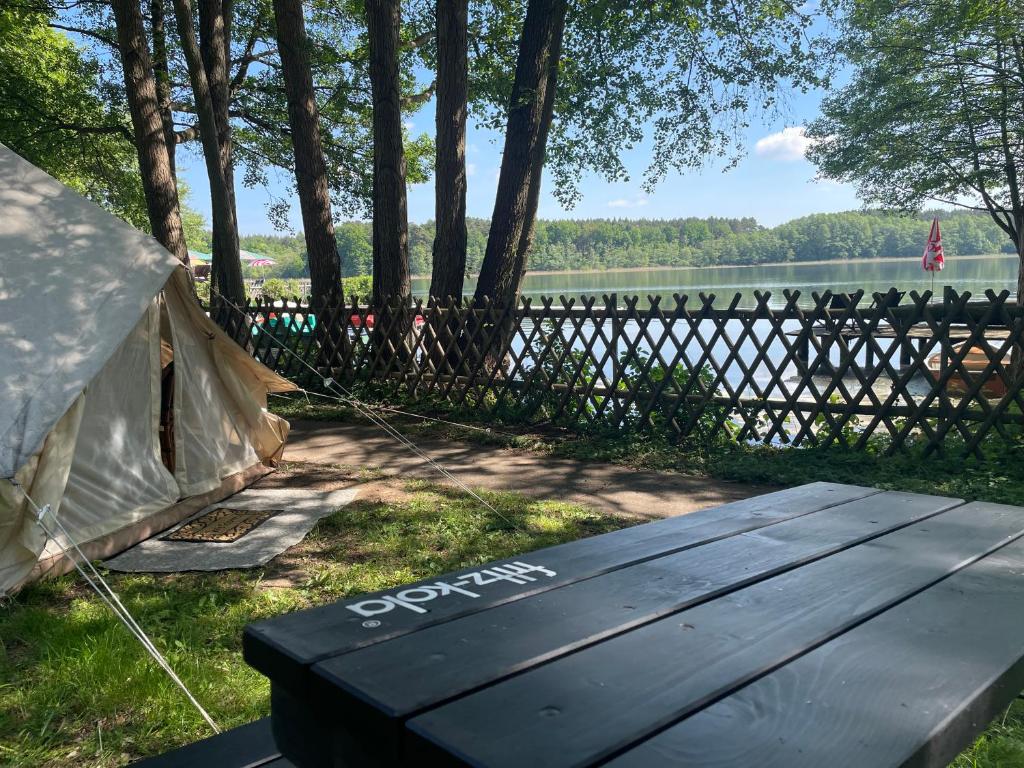 a tent with the word spencer on it next to a lake at Glamping Zelt in Templin