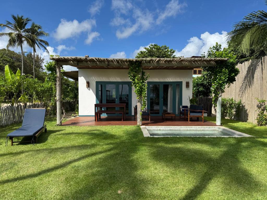 a small house with a patio and a yard at Casa Mar - Os Navegantes in Amontada