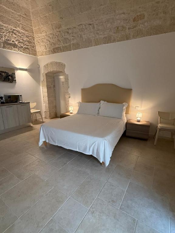 a bedroom with a large white bed in a room at Neptune Stone House in Molfetta