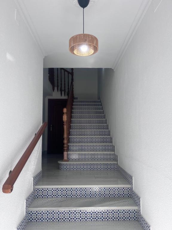 a staircase with blue and white tiles and a light at Bulevar Carlos III in La Carlota