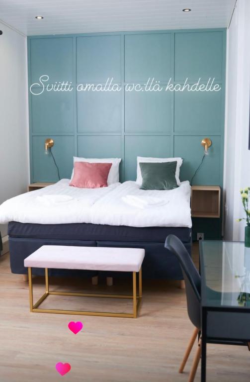 a bedroom with a bed with a table and a bench at Villa Korsman in Hanko
