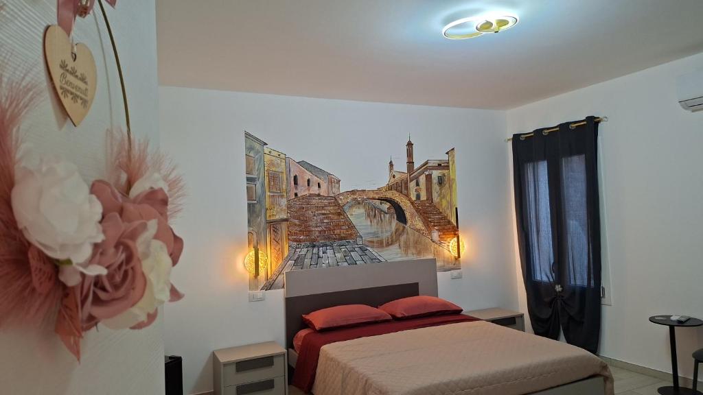 a bedroom with a bed and a painting of a bridge at Salicornia Rooms in Comacchio