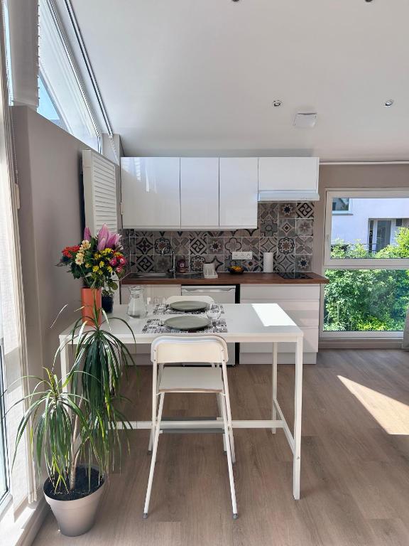 a kitchen with a white table and two plants at Le nid d'Eve - studio cosy près de Strasbourg avec piscine in Illkirch-Graffenstaden
