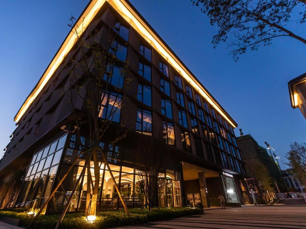 a large building with glass windows at night at Mercure Xichang in Xichang