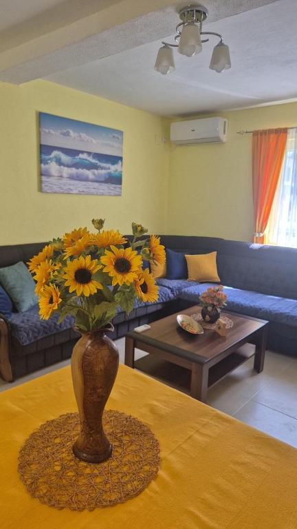 a vase with sunflowers on a table in a living room at Apartment Tamara in Tivat