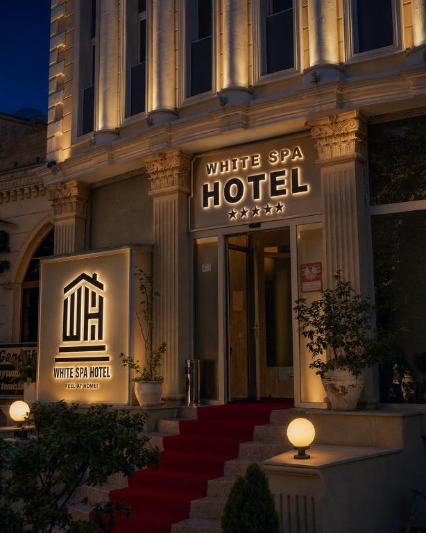 a building with a white spa hotel with a red carpeted stairs at White House SPA Hotel in Baku