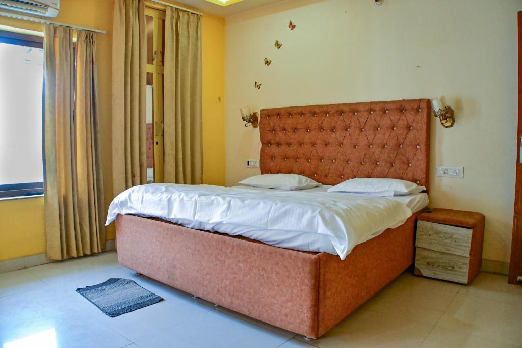 a bedroom with a large bed with a large headboard at Mahadev Mension Tapovan in Rishīkesh