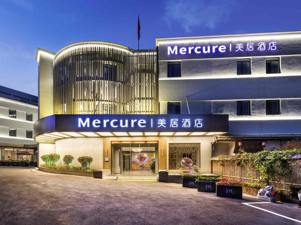 a large building with a sign on the front of it at Mercure Qingdao Downtown in Qingdao