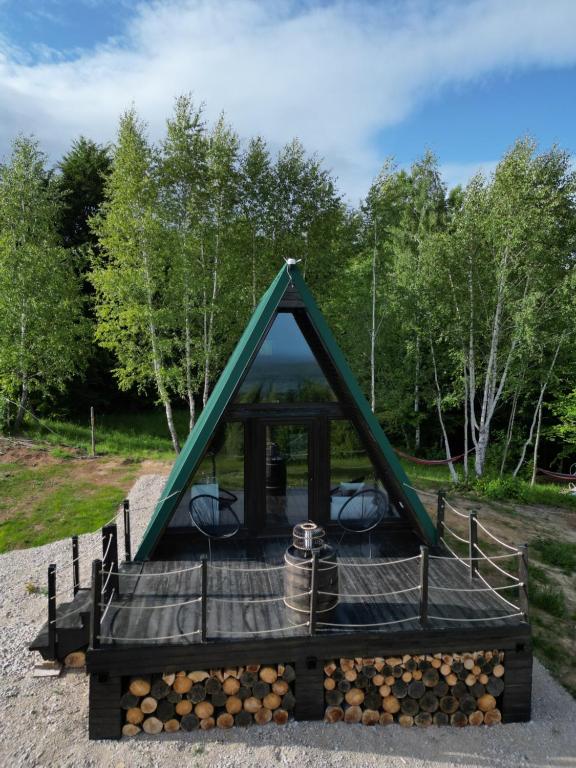 ein Haus mit dreieckigem Dach, mit einem Tisch und Stühlen in der Unterkunft Haiduk Aframe in Brebu