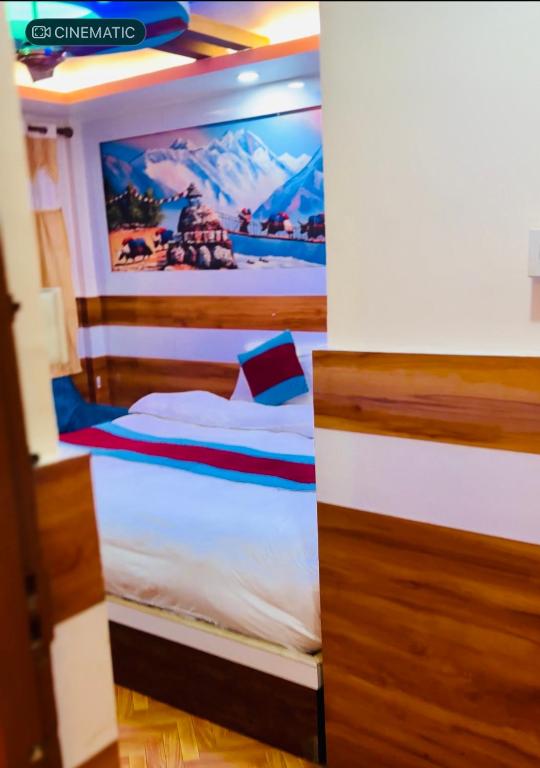 a bedroom with a bed with a painting on the wall at pokhara hotel Kathmandu pvt ltd in Kathmandu