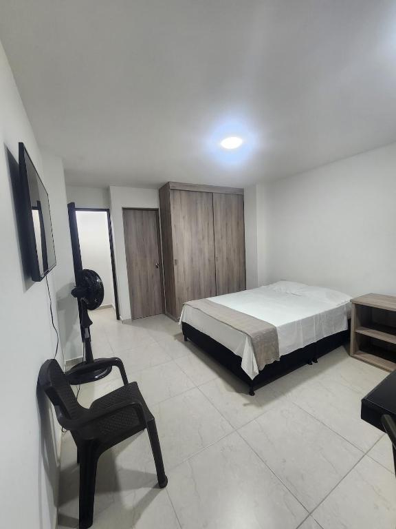 a bedroom with a bed and a chair in it at apartaestudio 304 tranquilo, cómodo y moderno in Tuluá