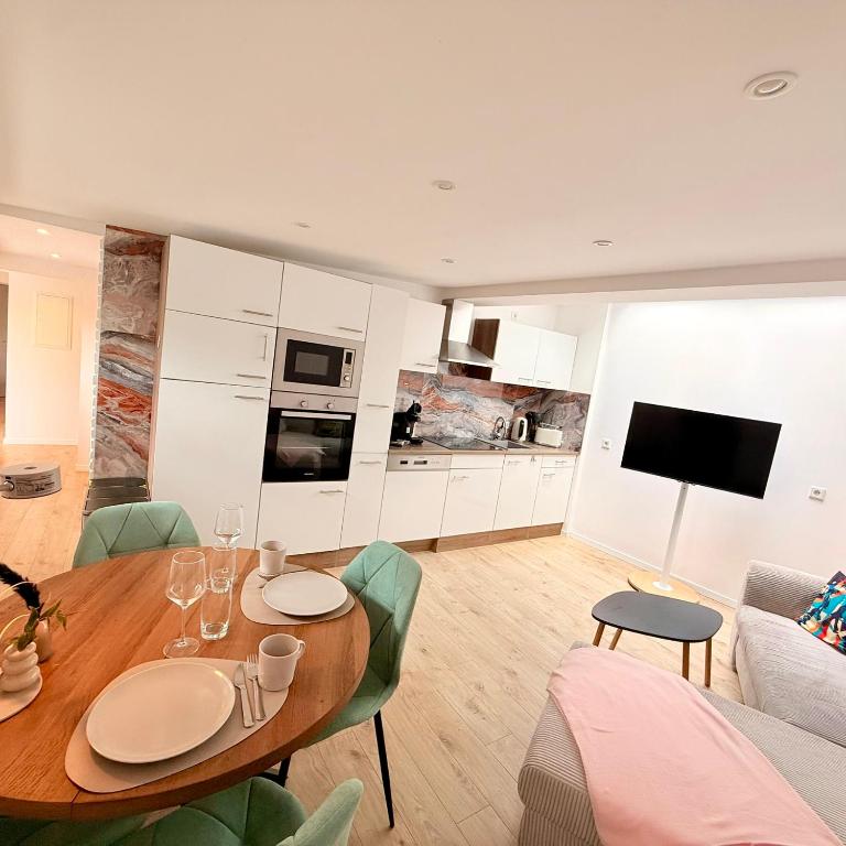 a living room with a table and a kitchen at Ewelinas Altstudio in Sundern